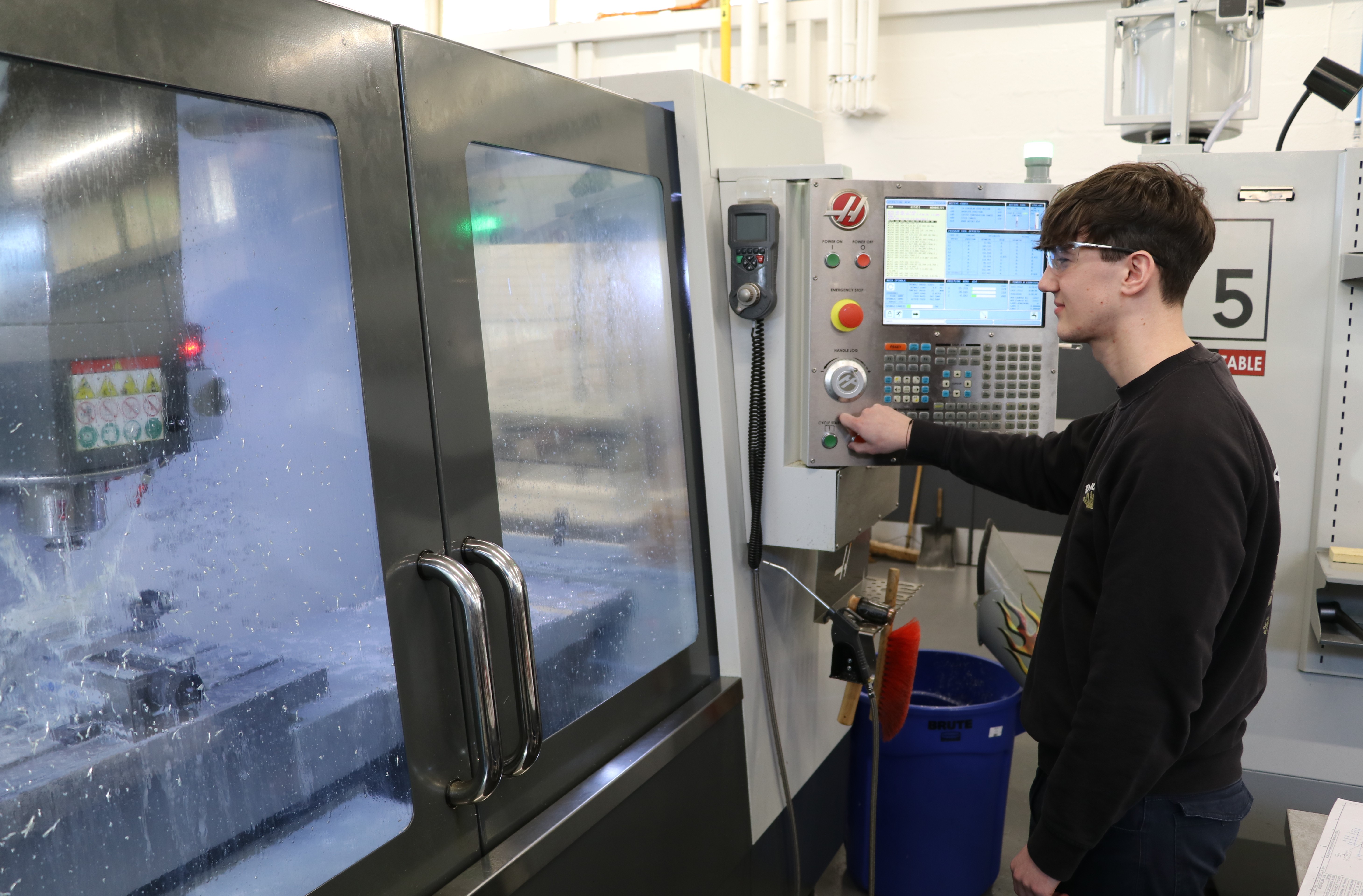 An apprentice working on a machine in the workshop on site at UK ATC.