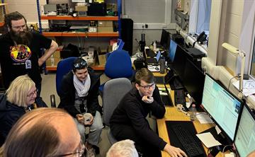 The MOONS software team gathered around a computer in the lab at UK ATC.